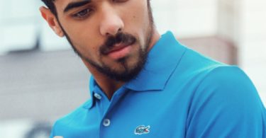 man wearing blue lacoste polo shirt and silver colored analog watch
