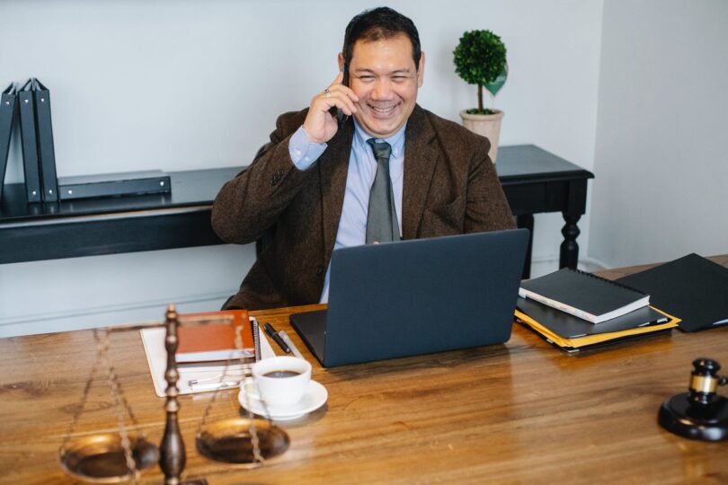 happy asian lawyer talking on smartphone in law office